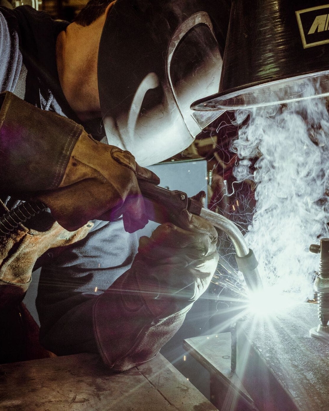 A welder at Dyna Metal Shop Seattle working on a piece of metal.