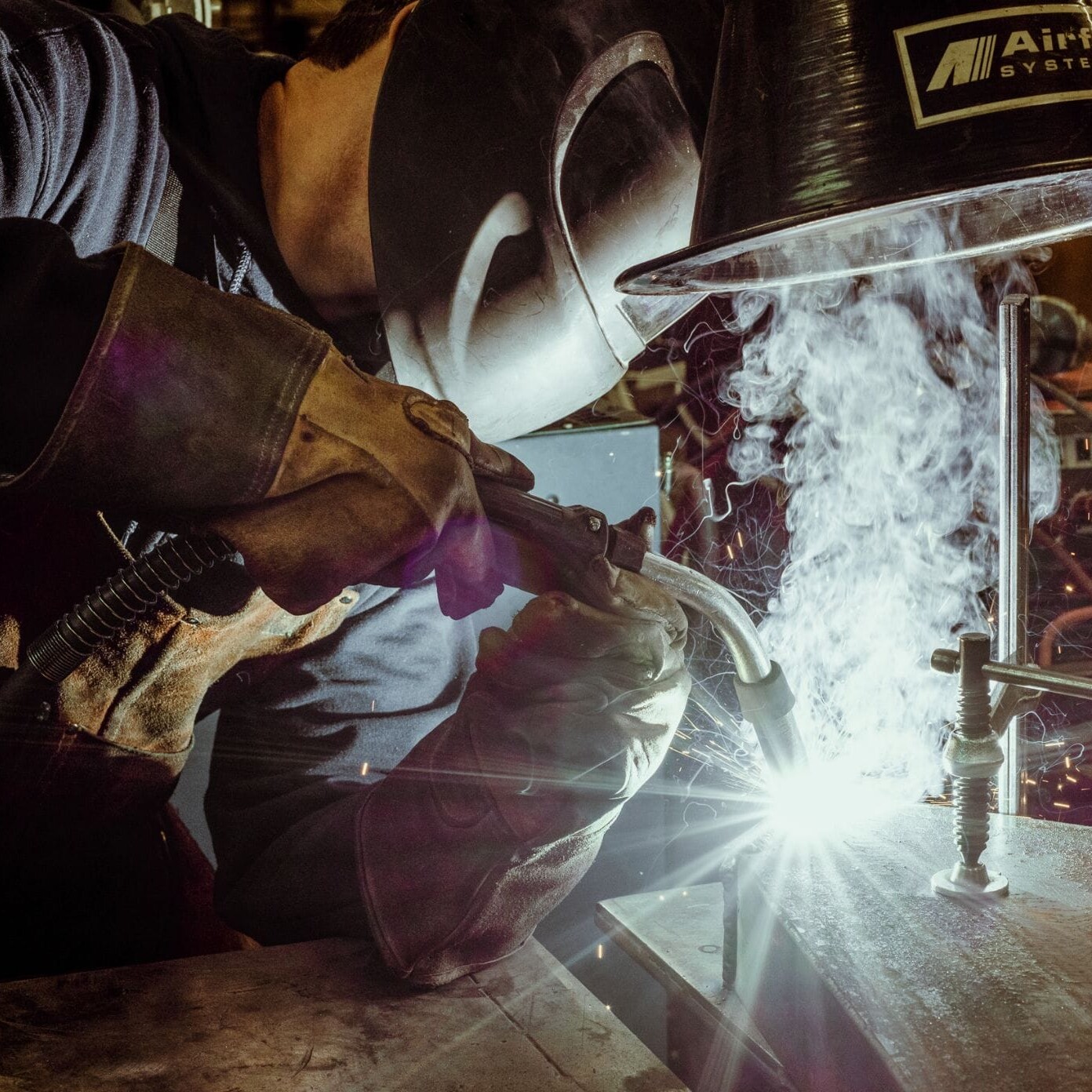 A welder at Dyna Metal Shop Seattle working on a piece of metal.