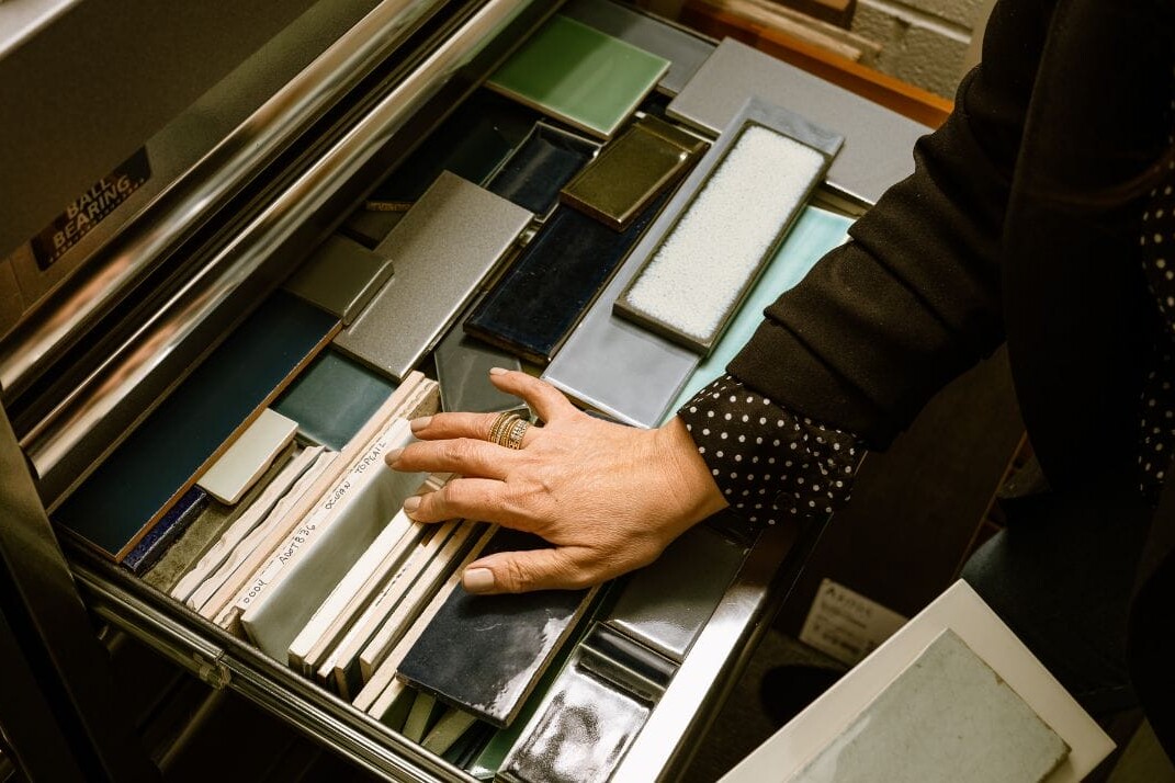 A person is opening a drawer full of Dyna Builders tiles.