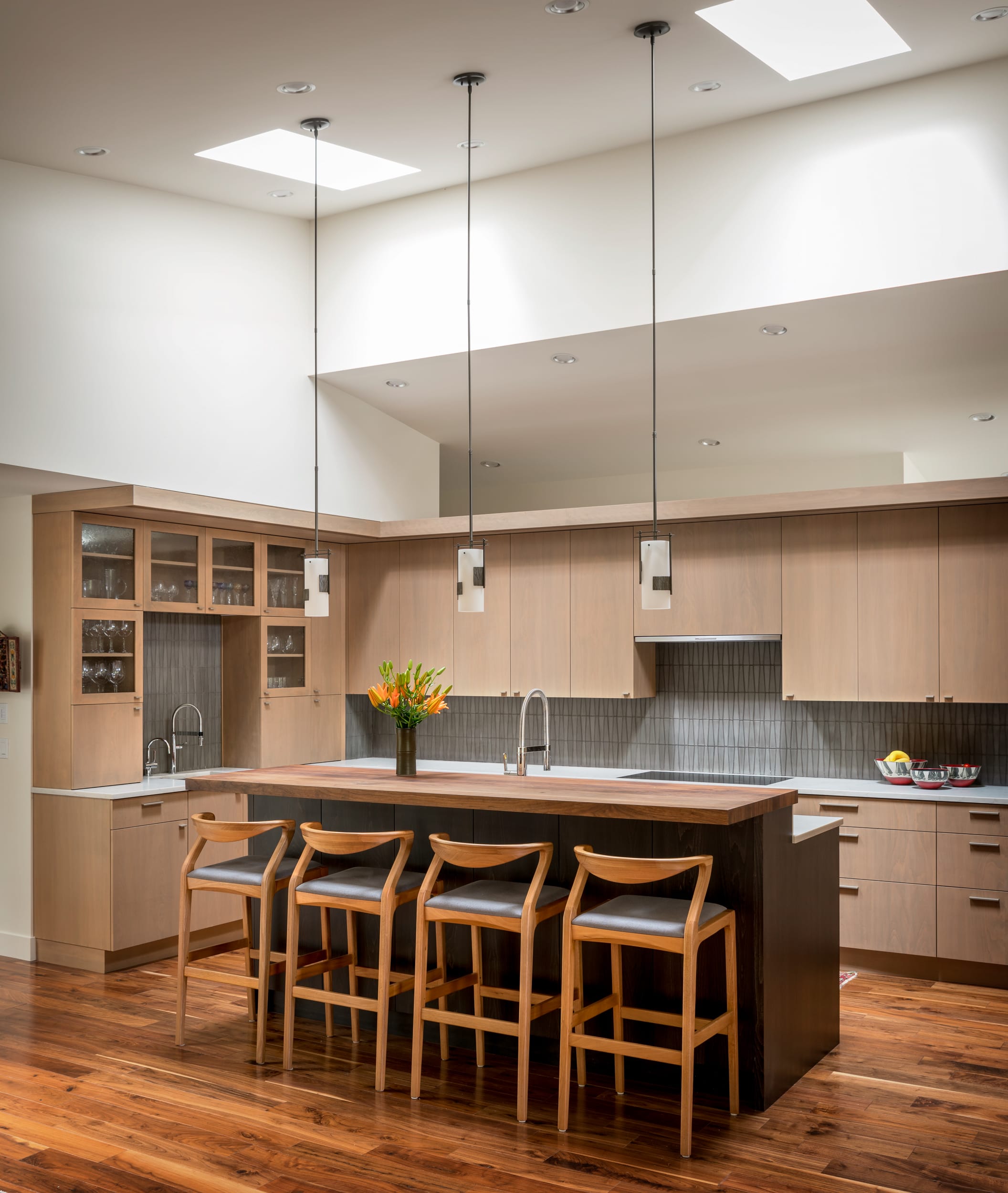 A modern kitchen with a center island and bar stools.